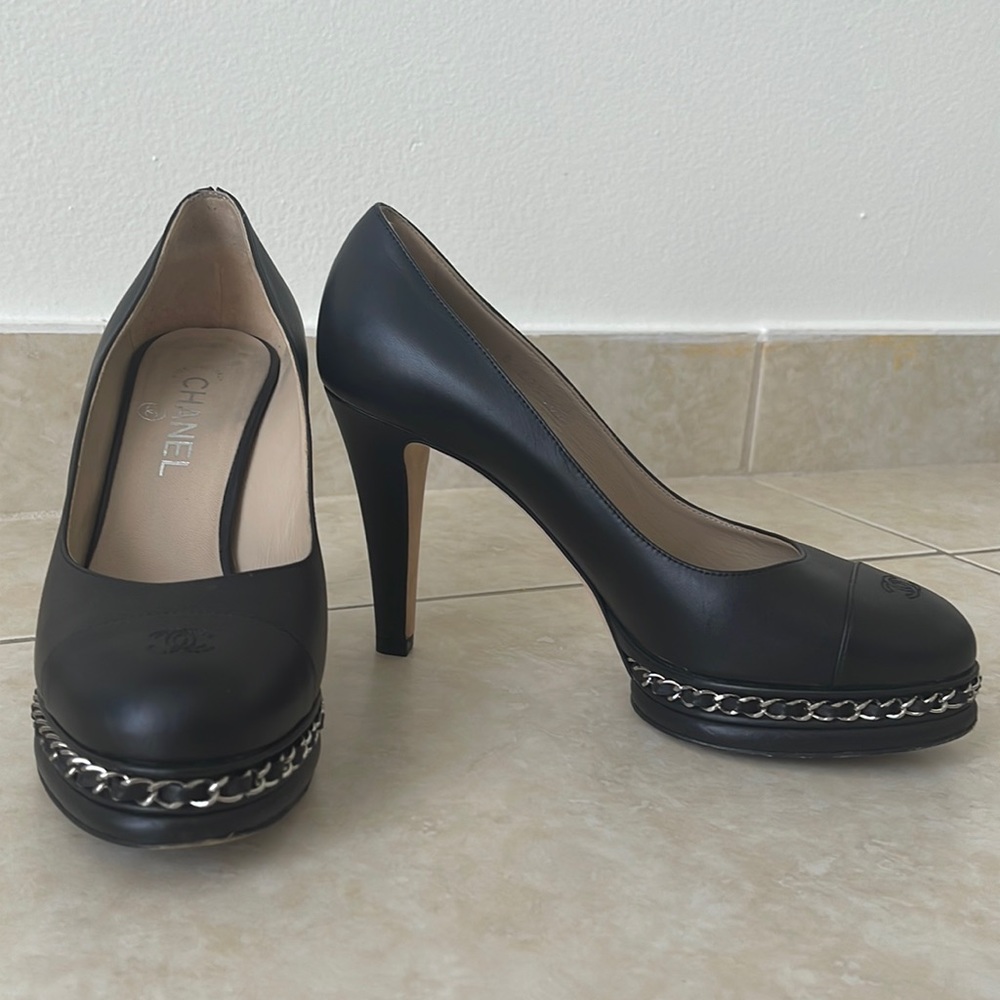 Chanel black leather heels with a small chain.